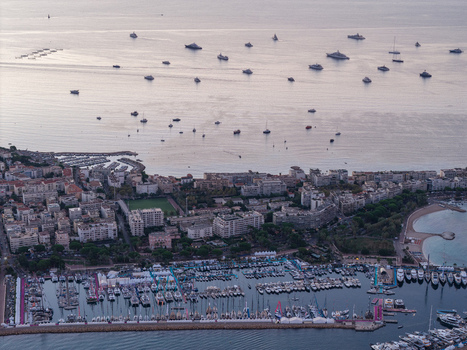 Aerial view of the harbor in Cannes with numerous yachts and boats docked at the marina surrounded by urban buildings and the Mediterranean Sea in Cannes Provence Alpes Cote d Azur France. Aerial view of the harbor in Cannes with numerous yachts and boats docked at the marina surrounded by urban buildings and the Mediterranean Sea in Cannes Provence Alpes Cote d Azur France.