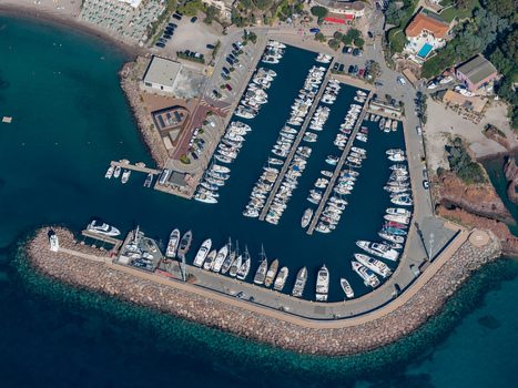 Aerial view of Le Trayas marina featuring docked yachts and boats within the stone breakwater surrounded by the Mediterranean Sea in Saint Raphael Provence Alpes Cote d Azur France. Aerial view of Le Trayas marina featuring docked yachts and boats within the stone breakwater surrounded by the Mediterranean Sea in Saint Raphael Provence Alpes Cote d Azur France.
