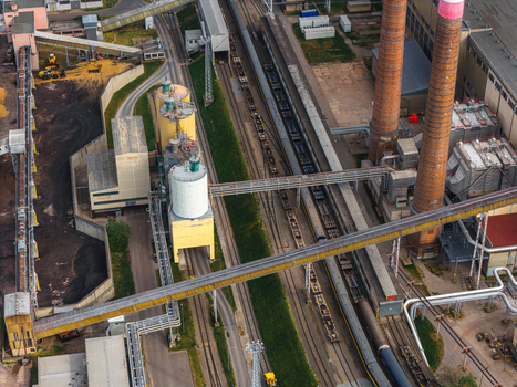 Aerial view of the Hodonin Power Station featuring tall industrial chimneys silos and railway tracks with freight cars at the industrial complex in Hodonin Jihomoravsky kraj Czechia. Aerial view of the Hodonin Power Station featuring tall industrial chimneys silos and railway tracks with freight cars at the industrial complex in Hodonin Jihomoravsky kraj Czechia.