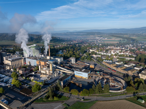 Aerial view of the Zuckerfabrik sugar factory featuring industrial buildings smoking chimneys and surrounding rural landscape in Aarberg Bern Switzerland. Aerial view of the Zuckerfabrik sugar factory featuring industrial buildings smoking chimneys and surrounding rural landscape in Aarberg Bern Switzerland.