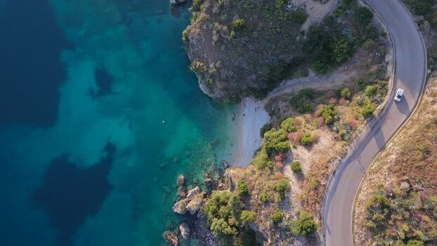 Aerial view of a car on a winding coastal road Albania.