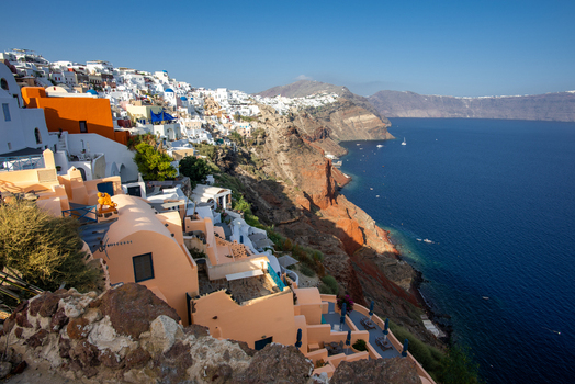 View of the white and orange buildings of Fira perched on the volcanic cliffs overlooking the Aegean Sea Fira Greece. View of the white and orange buildings of Fira perched on the volcanic cliffs overlooking the Aegean Sea Fira Greece.