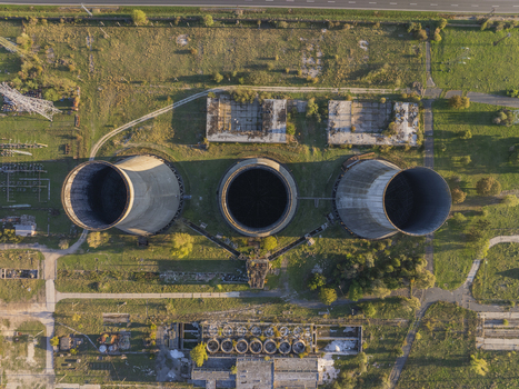 Aerial view of the abandoned Inota Power Plant cooling towers surrounded by grassy fields and industrial structures in Varpalota Hungary. Aerial view of the abandoned Inota Power Plant cooling towers surrounded by grassy fields and industrial structures in Varpalota Hungary.