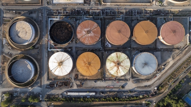 Aerial view of industrial storage tanks with colorful roofs and complex piping at a refinery facility in Cagliari Sardinia Italy. Aerial view of industrial storage tanks with colorful roofs and complex piping at a refinery facility in Cagliari Sardinia Italy.