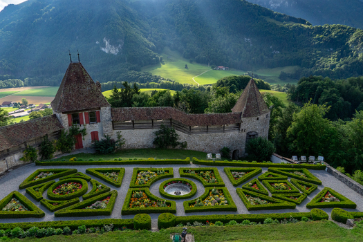 Gruyeres Switzerland 14 May 2026 Aerial view of Gruyeres Castle garden with geometric box hedges and stone walls against lush green mountains. Gruyeres Switzerland 14 May 2026 Aerial view of Gruyeres Castle garden with geometric box hedges and stone walls against lush green mountains.