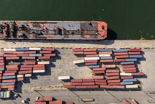 Aerial view of a large cargo ship docked at the Rio Ozama port with rows of colorful shipping containers stacked on the concrete pier in Santo Domingo Santo Domingo Dominican Republic.