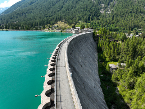 Aerial view of the Lago di Ceresole dam with turquoise alpine water and dense pine forests on the mountain slopes in Ceresole Reale Piedmont Italy. Aerial view of the Lago di Ceresole dam with turquoise alpine water and dense pine forests on the mountain slopes in Ceresole Reale Piedmont Italy.