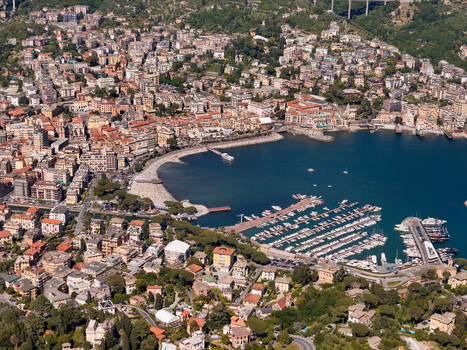 Aerial view of the city of Rapallo featuring the historic castle on the sea the harbor colorful buildings a sandy beach and numerous yachts in Rapallo Liguria Italy. Aerial view of the city of Rapallo featuring the historic castle on the sea the harbor colorful buildings a sandy beach and numerous yachts in Rapallo Liguria Italy.