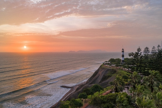 Aerial view of La Marina Lighthouse overlooking the Pacific Ocean cliffs during a vibrant sunset in Miraflores Lima Province Peru. Aerial view of La Marina Lighthouse overlooking the Pacific Ocean cliffs during a vibrant sunset in Miraflores Lima Province Peru.