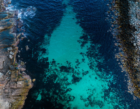 Aerial view of the rugged coastline of Torndirrup National Park featuring turquoise waters contrasting with dark rocky cliffs and stone formations in Torndirrup Western Australia Australia. Aerial view of the rugged coastline of Torndirrup National Park featuring turquoise waters contrasting with dark rocky cliffs and stone formations in Torndirrup Western Australia Australia.