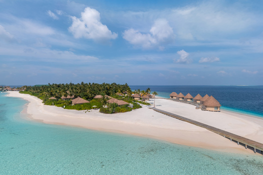 Aerial view of a tropical island resort s thatched roof villas and pristine white sands meet the turquoise sea under a serene sky Malé Malé Maldives. Aerial view of a tropical island resort s thatched roof villas and pristine white sands meet the turquoise sea under a serene sky Malé Malé Maldives.