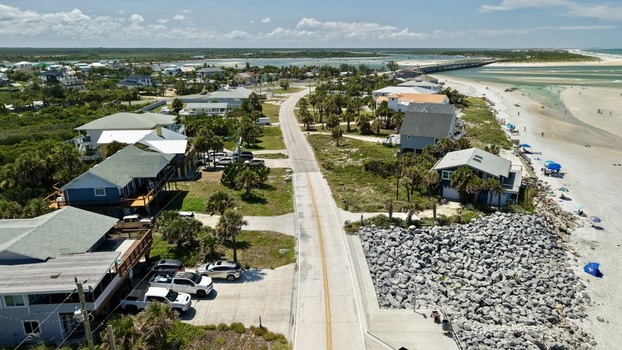 Aerial view of Matanzas Inlet featuring coastal homes a paved road rocky shoreline protection and a sandy beach in St. Johns County Florida United States. Aerial view of Matanzas Inlet featuring coastal homes a paved road rocky shoreline protection and a sandy beach in St. Johns County Florida United States.