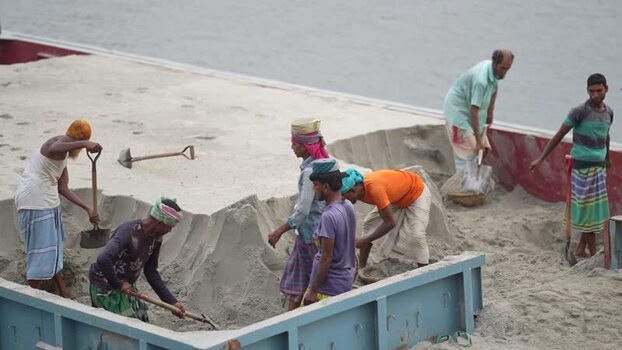 View of workers digging sand on a barge in Aminbazar Bangladesh. View of workers digging sand on a barge in Aminbazar Bangladesh.