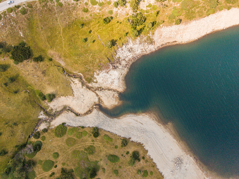 Aerial view of Belmeken reservoir showing the shoreline with grassy terrain and a road in Pazardzhik Bulgaria. Aerial view of Belmeken reservoir showing the shoreline with grassy terrain and a road in Pazardzhik Bulgaria.