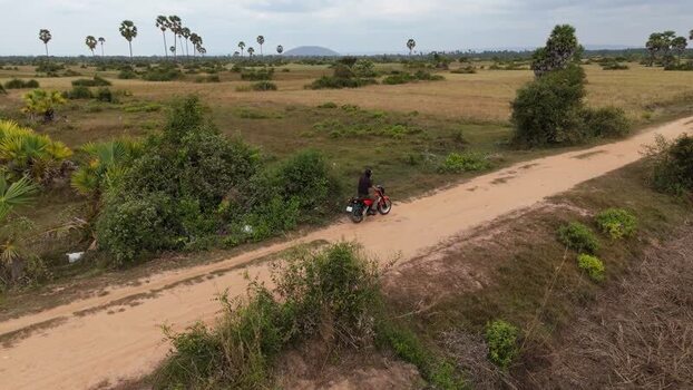Aerial view of motorcyclist on rural road in Cambodia. Aerial view of motorcyclist on rural road in Cambodia.