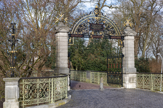 View of the ornate historic gate of the Voetgangersbrug Kelfkensbosch bridge with gold details and stone pillars in Nijmegen Gelderland Netherlands. View of the ornate historic gate of the Voetgangersbrug Kelfkensbosch bridge with gold details and stone pillars in Nijmegen Gelderland Netherlands.