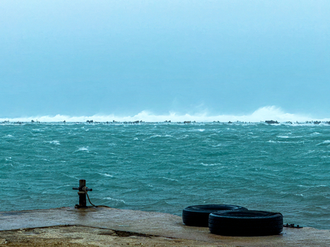 San Jose Tinian Northern Mariana Islands 06 July 2026 View of rough turbulent sea and crashing waves at Tinian Marina during Super Typhoon Bavi with a concrete pier and tires in the foreground. San Jose Tinian Northern Mariana Islands 06 July 2026 View of rough turbulent sea and crashing waves at Tinian Marina during Super Typhoon Bavi with a concrete pier and tires in the foreground.