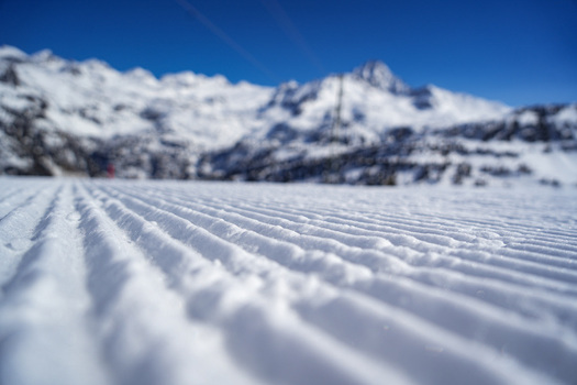 groomed snow corduroy on a ski slope with majestic snow capped mountains under a clear blue sky in La Thuile Valle d Aosta Italy. groomed snow corduroy on a ski slope with majestic snow capped mountains under a clear blue sky in La Thuile Valle d Aosta Italy.