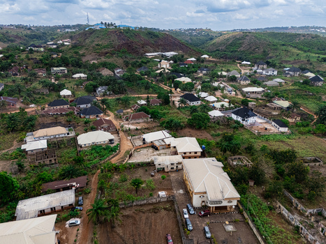 Aerial view of a sprawling residential area with diverse architectural styles nestled amidst lush green hills under an overcast sky ohafia Abia Nigeria. Aerial view of a sprawling residential area with diverse architectural styles nestled amidst lush green hills under an overcast sky ohafia Abia Nigeria.