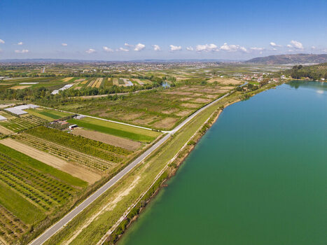 Aerial view of the lush agricultural fields and rural landscape surrounding the Liqeni Thanes reservoir in Lushnje Fier County Albania. Aerial view of the lush agricultural fields and rural landscape surrounding the Liqeni Thanes reservoir in Lushnje Fier County Albania.