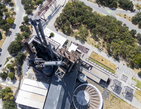 Aerial view of the industrial structures at Fundidora Park and the Paseo de la Mujer pathways surrounded by lush trees in Monterrey Nuevo Leon Mexico. Aerial view of the industrial structures at Fundidora Park and the Paseo de la Mujer pathways surrounded by lush trees in Monterrey Nuevo Leon Mexico.