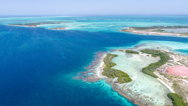 Aerial view of Los Roques archipelago featuring turquoise waters coral reefs small islands with mangroves and pink salt flats Los Roques Dependencias Federale Venezuela. Aerial view of Los Roques archipelago featuring turquoise waters coral reefs small islands with mangroves and pink salt flats Los Roques Dependencias Federale Venezuela.