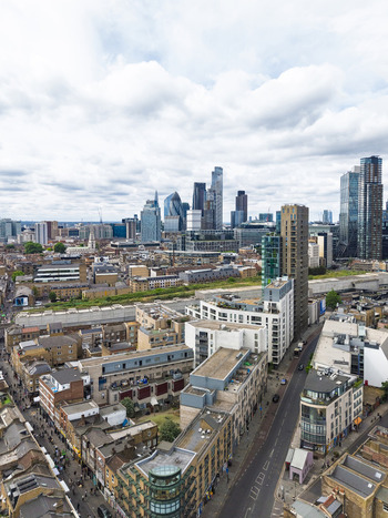 Aerial view of Shoreditch with its mix of historic and modern architecture bustling streets and the distant London skyline under a cloudy sky in London England United Kingdom. Aerial view of Shoreditch with its mix of historic and modern architecture bustling streets and the distant London skyline under a cloudy sky in London England United Kingdom.