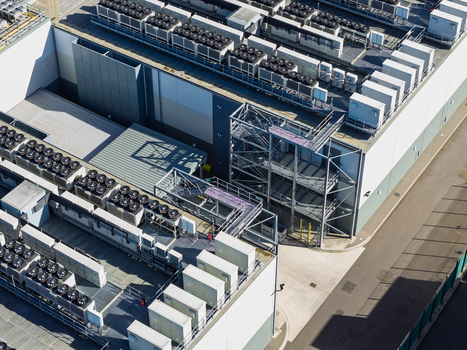 Aerial view of a data center with numerous rooftop cooling units and industrial infrastructure in the United Kingdom.