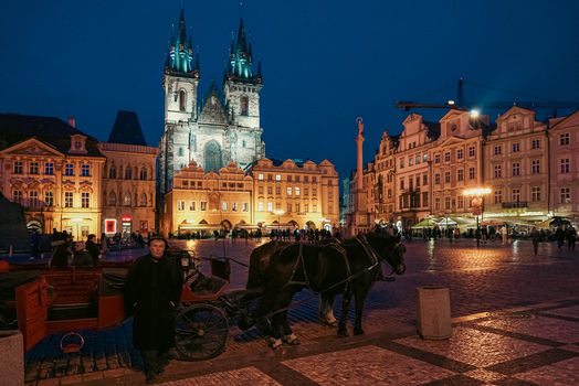Prague Czechia 03 November 2021 View of the Church of Our Lady before Tyn at night with a horse drawn carriage and driver in the Old Town Square. Prague Czechia 03 November 2021 View of the Church of Our Lady before Tyn at night with a horse drawn carriage and driver in the Old Town Square.