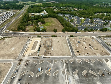 Aerial view of the construction site at Foundry Lane featuring heavy machinery dirt plots and new roads near residential areas in World Golf Village Florida United States.