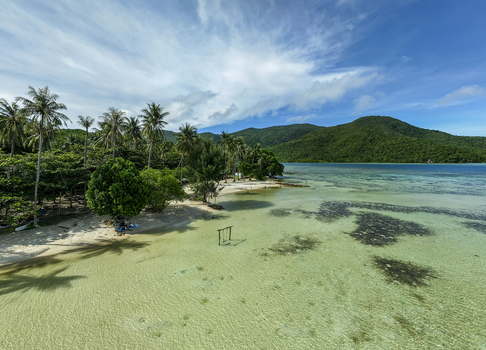 Aerial view of Bobby Beach where turquoise waters meet pristine sands under a vast sky Karimunjawa Central Java Indonesia.
