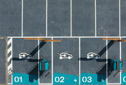 Aerial view of electric vehicle charging stations with numbered parking spots and charging units on a paved lot in Beilen Drenthe Netherlands.