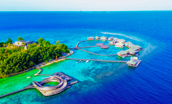 Aerial view of Karimun Jawa resort with overwater bungalows wooden walkways and lush vegetation set in turquoise waters off the coast of Jepara Central Java Indonesia. Aerial view of Karimun Jawa resort with overwater bungalows wooden walkways and lush vegetation set in turquoise waters off the coast of Jepara Central Java Indonesia.