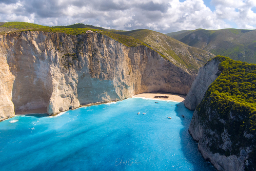 Aerial view of Navagio Beach with its iconic shipwreck turquoise waters and towering limestone cliffs in Zakynthos Navagio Greece.