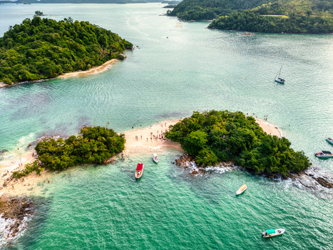 Aerial view of Ilha Cataguas with its white sand beach turquoise waters and boats anchored in the tropical bay of Rio de Janeiro Brazil. Aerial view of Ilha Cataguas with its white sand beach turquoise waters and boats anchored in the tropical bay of Rio de Janeiro Brazil.