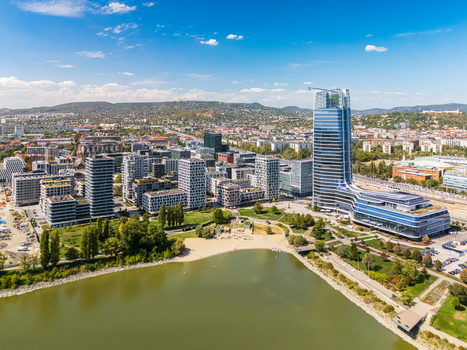 Aerial view of Mol Campus and the Budapest skyline along the Danube near Kopaszi Dam with modern office buildings riverside parks roads and the Buda Hills in summer. Aerial view of Mol Campus and the Budapest skyline along the Danube near Kopaszi Dam with modern office buildings riverside parks roads and the Buda Hills in summer.