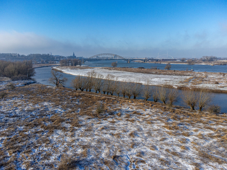 Aerial view of the snow dusted landscape and the iconic bridge reflecting in the calm waters of the river Tiengeboden Gelderland Netherlands. Aerial view of the snow dusted landscape and the iconic bridge reflecting in the calm waters of the river Tiengeboden Gelderland Netherlands.