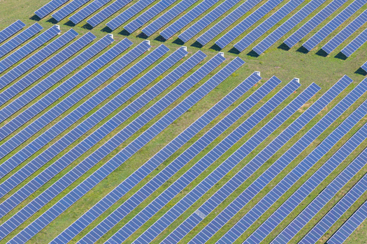 Aerial view of a large solar farm with rows of photovoltaic panels installed on a grassy field in the countryside Arezzo Tuscany Italy. Aerial view of a large solar farm with rows of photovoltaic panels installed on a grassy field in the countryside Arezzo Tuscany Italy.