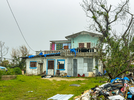 San Jose Tinian Northern Mariana Islands 06 July 2026 View of a damaged house with blue tarps on the roof and debris in the yard after a super typhoon. San Jose Tinian Northern Mariana Islands 06 July 2026 View of a damaged house with blue tarps on the roof and debris in the yard after a super typhoon.