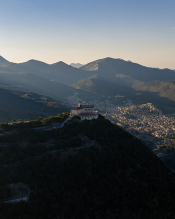 Aerial view of Santuario del Santissimo Salvatore on a forested hilltop overlooking the town of Montella and the surrounding mountains Montella Campania Italy. Aerial view of Santuario del Santissimo Salvatore on a forested hilltop overlooking the town of Montella and the surrounding mountains Montella Campania Italy.