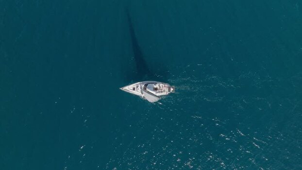Aerial view of a sailboat cruising on the blue sea Italy.