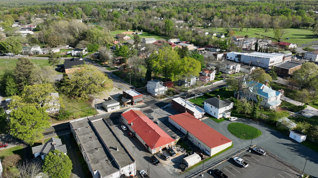 Aerial view of Appomattox featuring historic buildings with red metal roofs surrounding residential houses lush green trees and local streets in Appomattox Virginia United States.