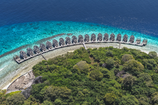 Aerial view of an abandoned island resort with lush green vegetation white sandy beaches and turquoise coral reefs surrounded by deep blue ocean waters in Muraidhoo Haa Alif Atoll Maldives. Aerial view of an abandoned island resort with lush green vegetation white sandy beaches and turquoise coral reefs surrounded by deep blue ocean waters in Muraidhoo Haa Alif Atoll Maldives.