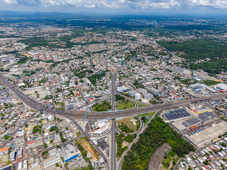 Aerial view of the Autopista Juan Pablo Duarte Km 9 interchange surrounded by urban development and industrial areas in Santo Domingo Distrito Nacional Dominican Republic. Aerial view of the Autopista Juan Pablo Duarte Km 9 interchange surrounded by urban development and industrial areas in Santo Domingo Distrito Nacional Dominican Republic.