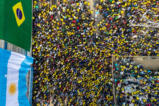 Dhaka Bangladesh 20 June 2026 Aerial view of a large crowd of football fans in yellow shirts at Dhaka University Campus with large Brazilian and Argentine flags displayed. Dhaka Bangladesh 20 June 2026 Aerial view of a large crowd of football fans in yellow shirts at Dhaka University Campus with large Brazilian and Argentine flags displayed.
