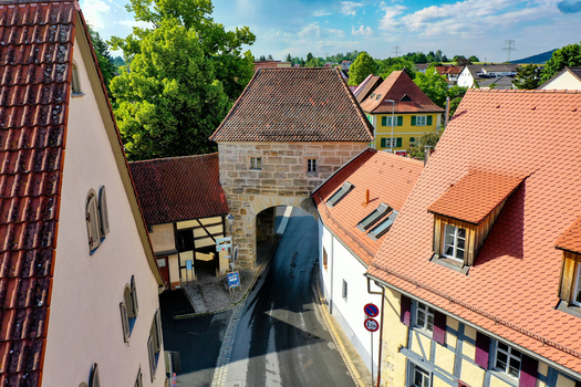 Aerial view of the historic Erlanger Tor gate surrounded by traditional half timbered houses and red tiled rooftops under a bright sky in Neunkirchen am Brand Bavaria Germany. Aerial view of the historic Erlanger Tor gate surrounded by traditional half timbered houses and red tiled rooftops under a bright sky in Neunkirchen am Brand Bavaria Germany.
