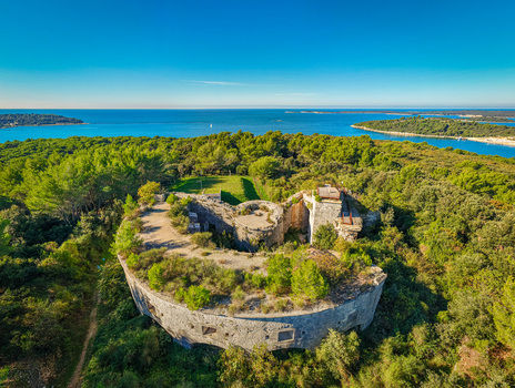 Aerial view of Fortress Bourguignon embraced by lush green forests with the Adriatic Sea shimmering in the distance Pula Istria County Croatia. Aerial view of Fortress Bourguignon embraced by lush green forests with the Adriatic Sea shimmering in the distance Pula Istria County Croatia.