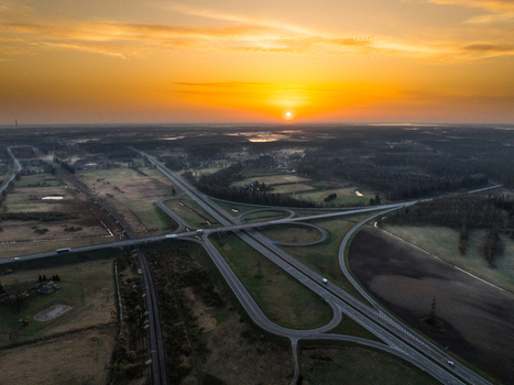Aerial view of the A5 and A8 highway interchange at sunrise featuring surrounding fields and forests in Olaine parish Olaine Municipality Latvia. Aerial view of the A5 and A8 highway interchange at sunrise featuring surrounding fields and forests in Olaine parish Olaine Municipality Latvia.