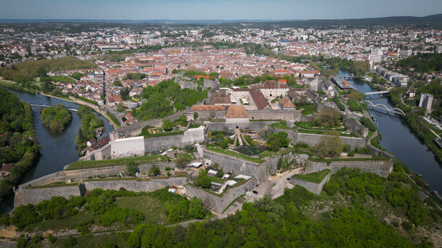 Aerial view of the Besancon Citadel overlooking the Doubs river and the city center with its red tiled rooftops under a clear blue sky Besancon Bourgogne Franche Comte France. Aerial view of the Besancon Citadel overlooking the Doubs river and the city center with its red tiled rooftops under a clear blue sky Besancon Bourgogne Franche Comte France.