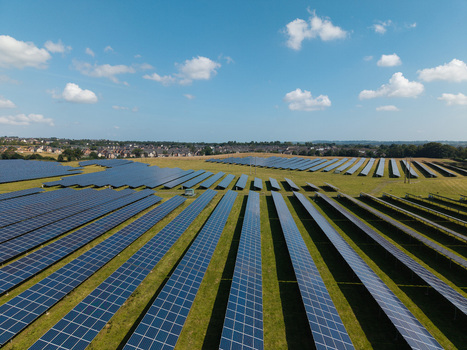 Aerial view of Lisburn Solar Farm with rows of photovoltaic panels set in green fields under a clear blue sky in Lisburn Northern Ireland United Kingdom. Aerial view of Lisburn Solar Farm with rows of photovoltaic panels set in green fields under a clear blue sky in Lisburn Northern Ireland United Kingdom.